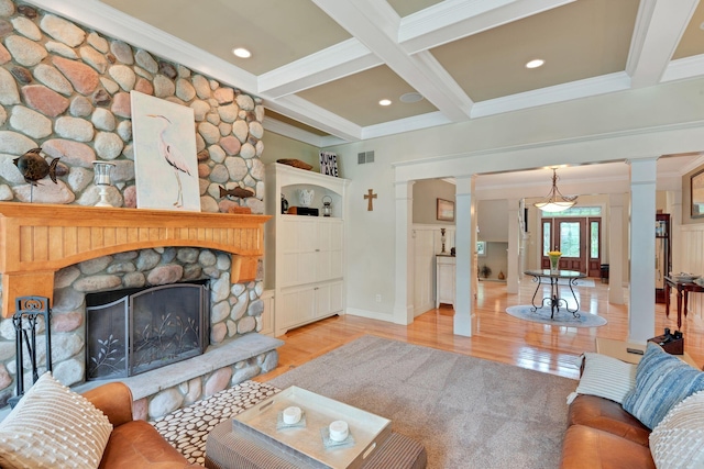 living area with beamed ceiling, visible vents, a fireplace, and ornate columns