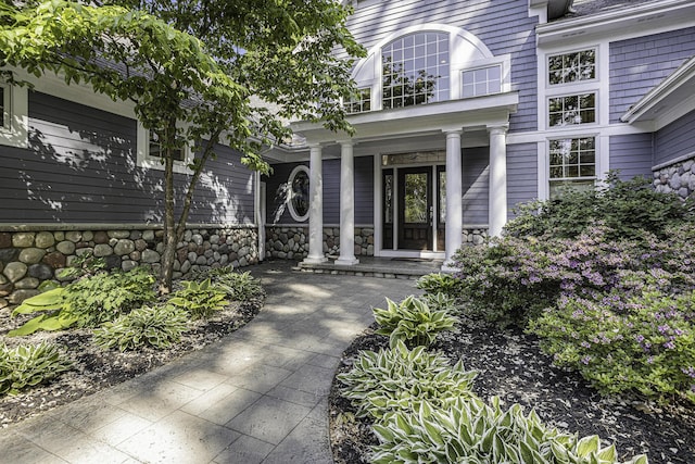 entrance to property with stone siding and covered porch