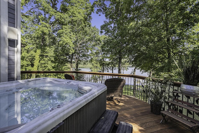 wooden deck with a grill, a water view, and a hot tub