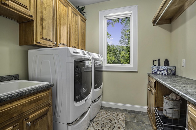 washroom with washer and dryer, cabinet space, and baseboards