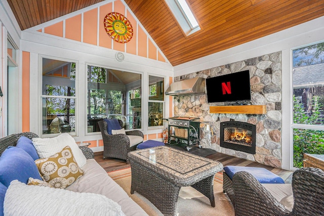 sunroom / solarium with wood ceiling, vaulted ceiling with skylight, and a fireplace