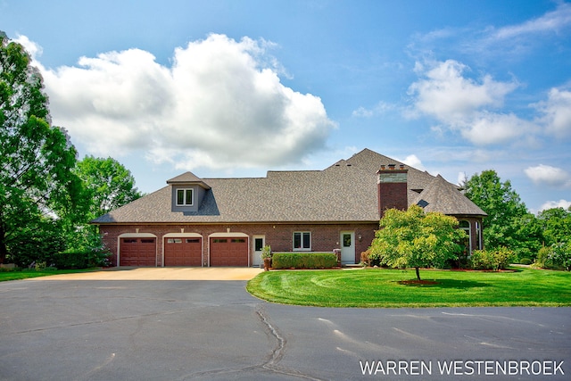 new england style home featuring a garage and a front lawn