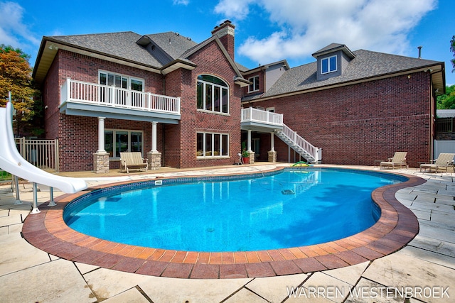 view of swimming pool with a patio and a water slide