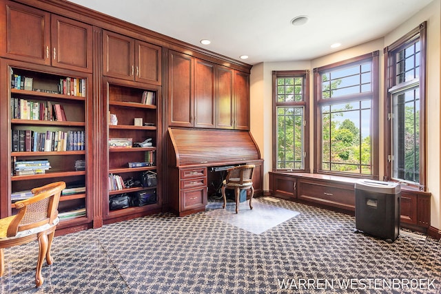 carpeted home office featuring built in desk