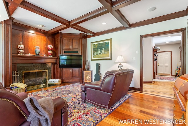 living room featuring beamed ceiling, coffered ceiling, a high end fireplace, and light hardwood / wood-style floors