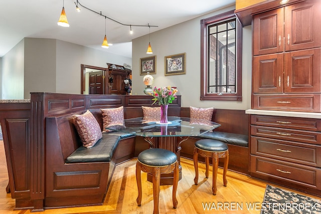 dining room featuring breakfast area, track lighting, and light hardwood / wood-style floors