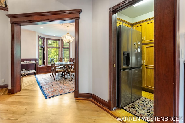 hall with an inviting chandelier and light hardwood / wood-style floors