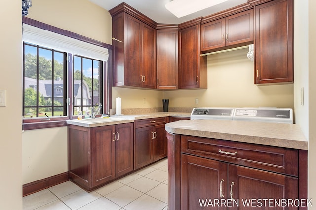 kitchen with light tile patterned flooring, washing machine and clothes dryer, and sink