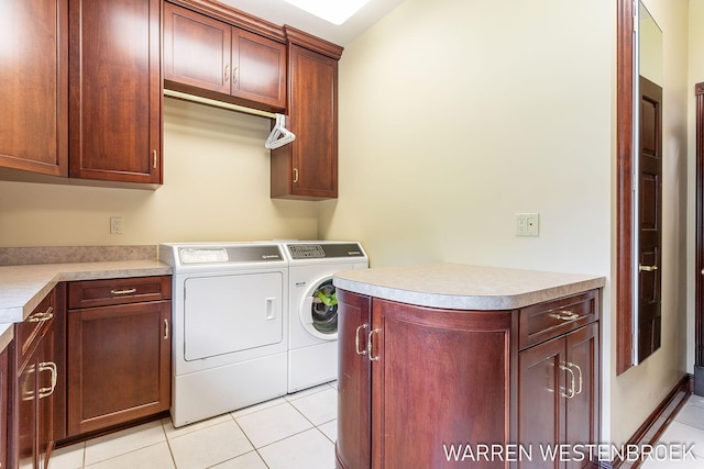 clothes washing area featuring cabinets, washing machine and dryer, and light tile patterned floors