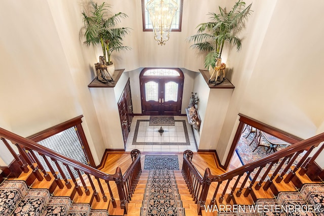 entryway with an inviting chandelier, light hardwood / wood-style flooring, and a high ceiling