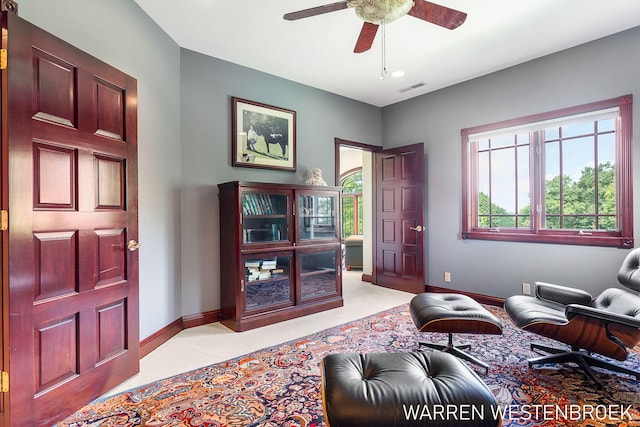 interior space featuring ceiling fan and light colored carpet