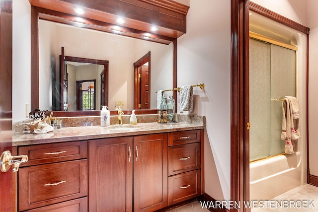 bathroom featuring vanity, tile patterned flooring, and bath / shower combo with glass door