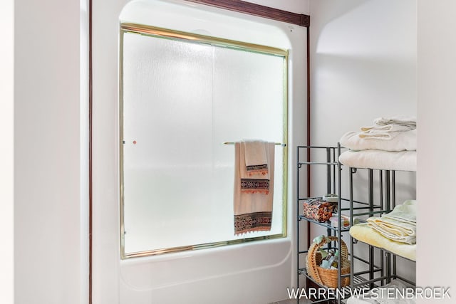 bathroom with combined bath / shower with glass door