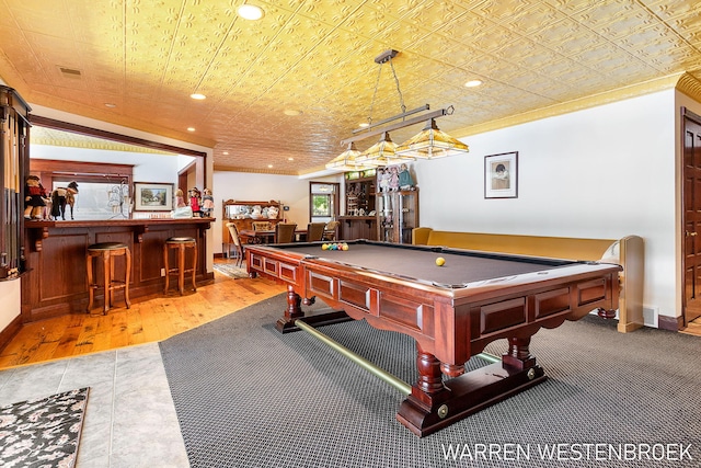 game room with ornamental molding and bar