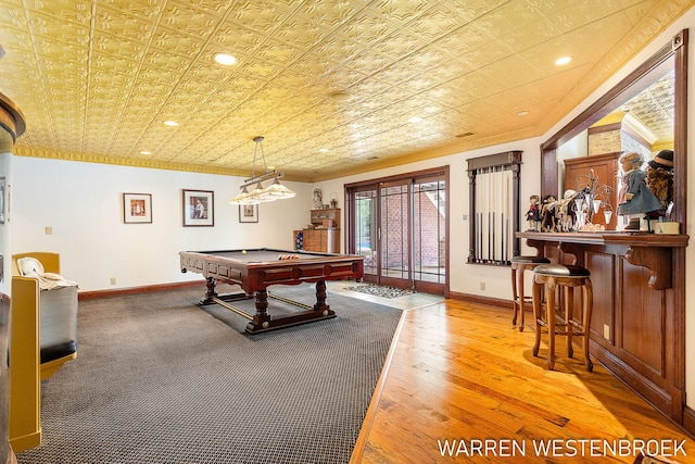 game room featuring hardwood / wood-style floors, ornamental molding, bar, and pool table