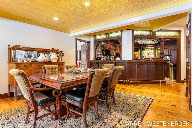 dining area featuring bar and light hardwood / wood-style floors