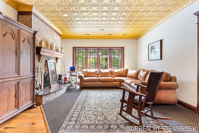 living room with crown molding, a large fireplace, and light hardwood / wood-style flooring