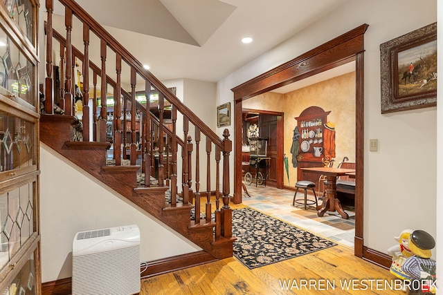 staircase with hardwood / wood-style flooring and heating unit