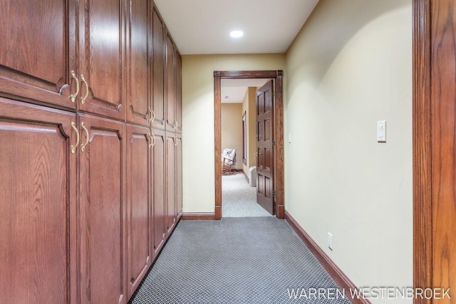 hallway featuring dark carpet