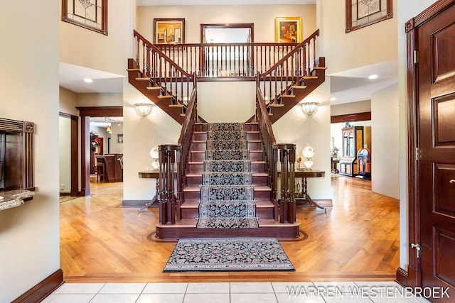 stairway with hardwood / wood-style floors and a high ceiling