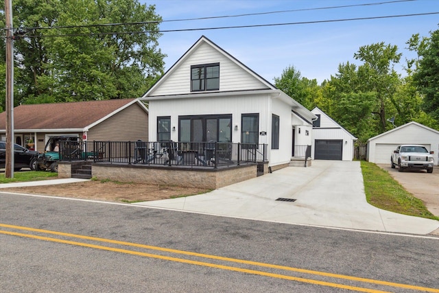 view of front of house with a garage and an outbuilding