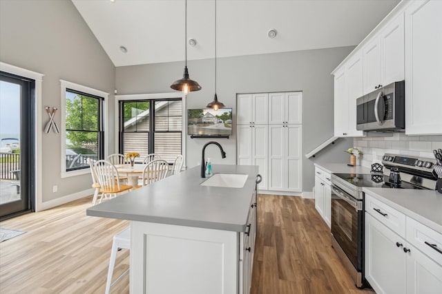 kitchen featuring white cabinetry, an island with sink, appliances with stainless steel finishes, and sink