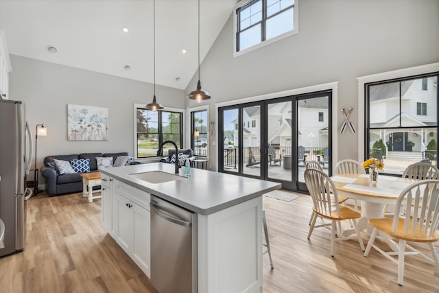 kitchen featuring sink, white cabinetry, hanging light fixtures, a kitchen island with sink, and stainless steel appliances