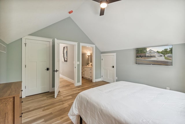 bedroom with lofted ceiling, connected bathroom, light hardwood / wood-style floors, and ceiling fan