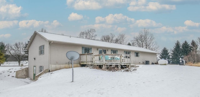 snow covered back of property featuring a wooden deck