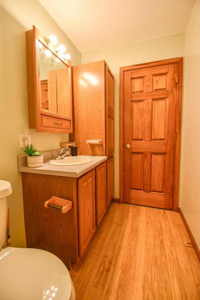 bathroom featuring hardwood / wood-style flooring, vanity, and toilet