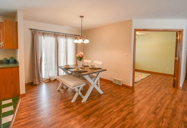 dining room with wood-type flooring and a chandelier