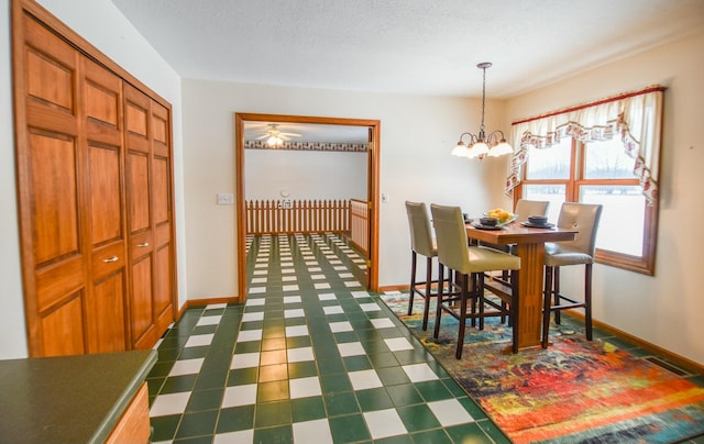 dining space with ceiling fan with notable chandelier and a textured ceiling