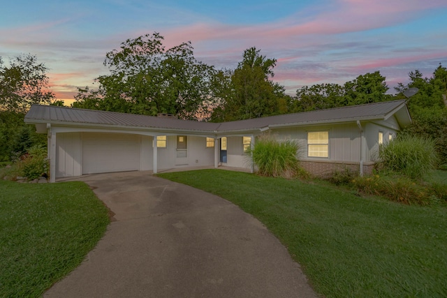 single story home with a garage and a yard