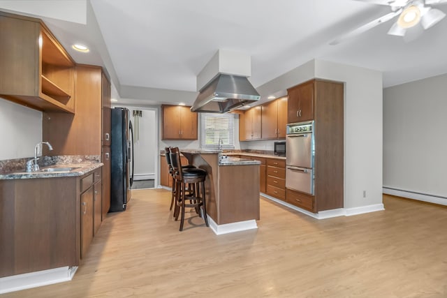 kitchen with light hardwood / wood-style floors, black appliances, island exhaust hood, and ceiling fan