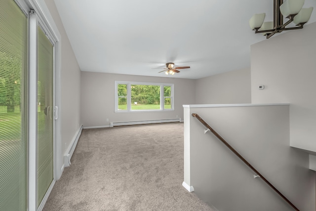 empty room featuring a baseboard heating unit, light carpet, and ceiling fan