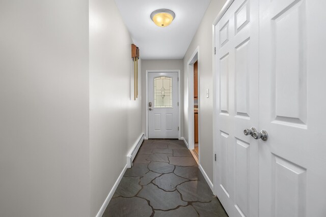 corridor with a baseboard radiator and tile patterned flooring