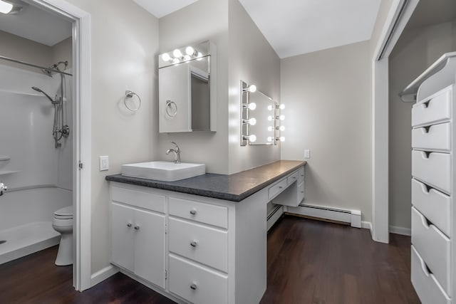 bathroom with vanity, toilet, a baseboard heating unit, and hardwood / wood-style flooring