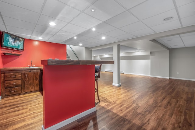 interior space featuring wood-type flooring, a drop ceiling, and sink