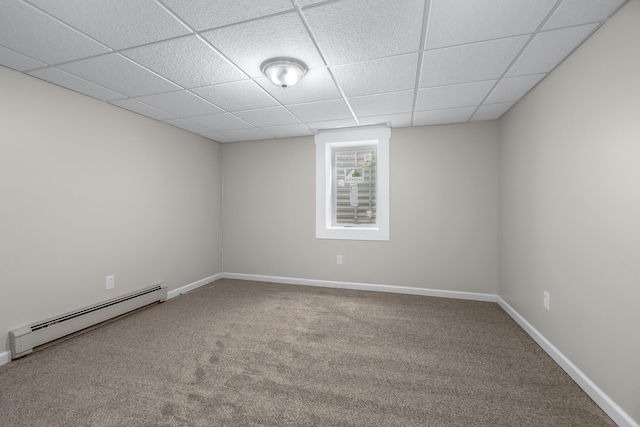 unfurnished room with a baseboard radiator, carpet, and a paneled ceiling