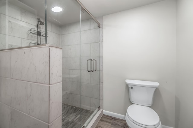 bathroom featuring walk in shower, hardwood / wood-style flooring, and toilet