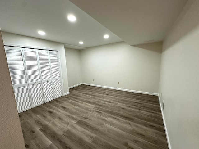 unfurnished bedroom with dark wood-type flooring and a closet