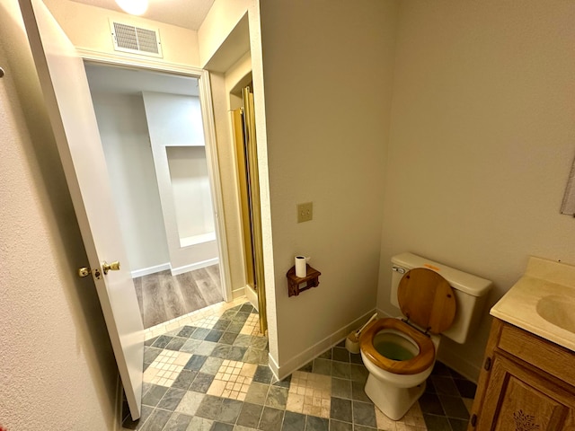 bathroom with vanity, a shower with shower door, and toilet