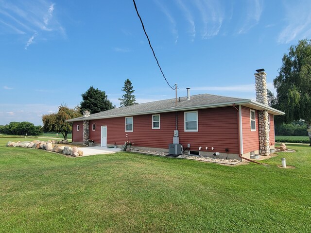 back of house with central air condition unit, a patio area, and a yard