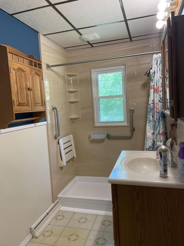 bathroom with walk in shower, tile patterned floors, vanity, and baseboard heating