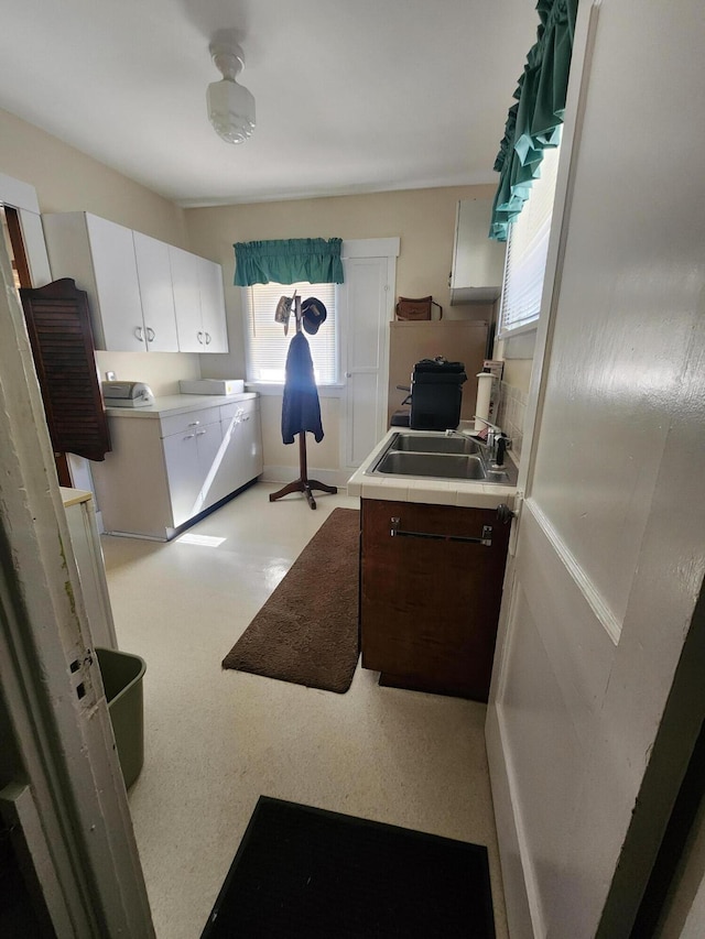 kitchen featuring dark brown cabinetry, separate washer and dryer, sink, and white cabinets