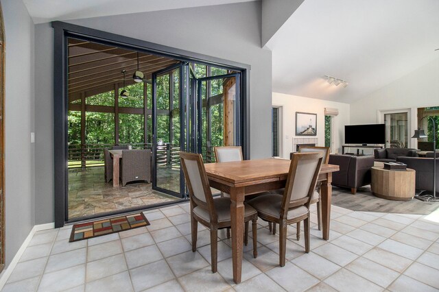 dining space featuring high vaulted ceiling and light tile patterned floors