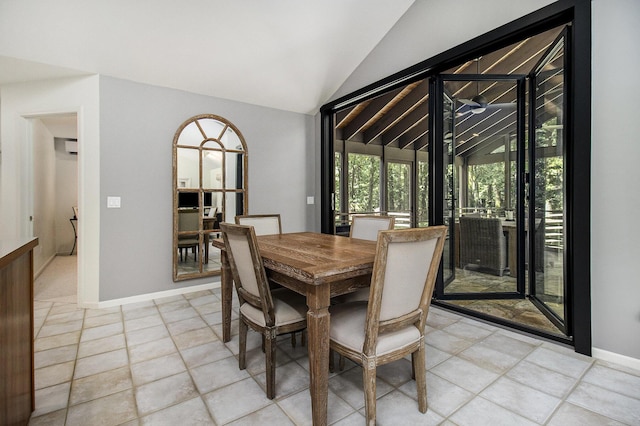 dining room featuring lofted ceiling, light tile patterned floors, and baseboards