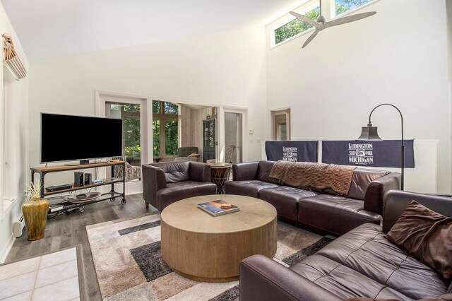 living room with a healthy amount of sunlight, a high ceiling, hardwood / wood-style floors, and ceiling fan