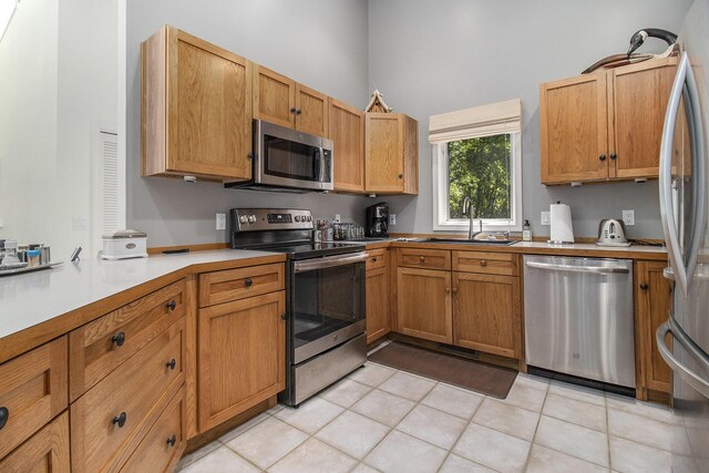 kitchen featuring high vaulted ceiling, sink, stainless steel appliances, and light tile patterned floors