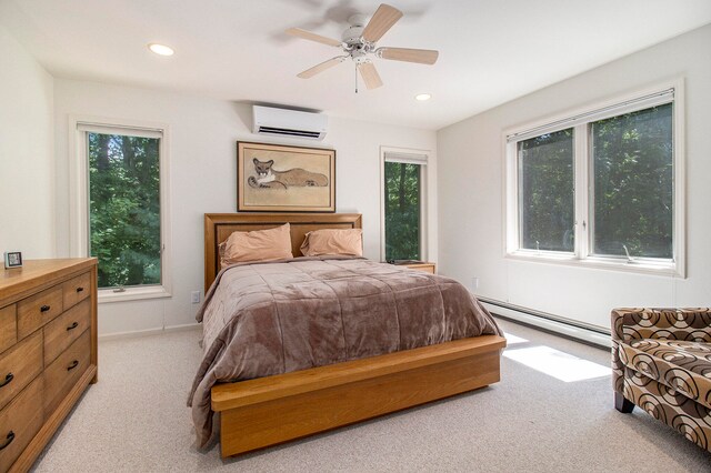 carpeted bedroom featuring a wall unit AC, ceiling fan, and baseboard heating